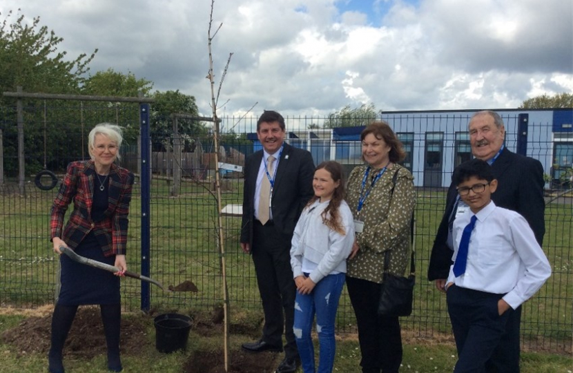 Karina Garrick, Headteacher at Corringham Primary School, and Stephen Metcalfe are helped by pupils to plant a coronation oak tree on Friday.